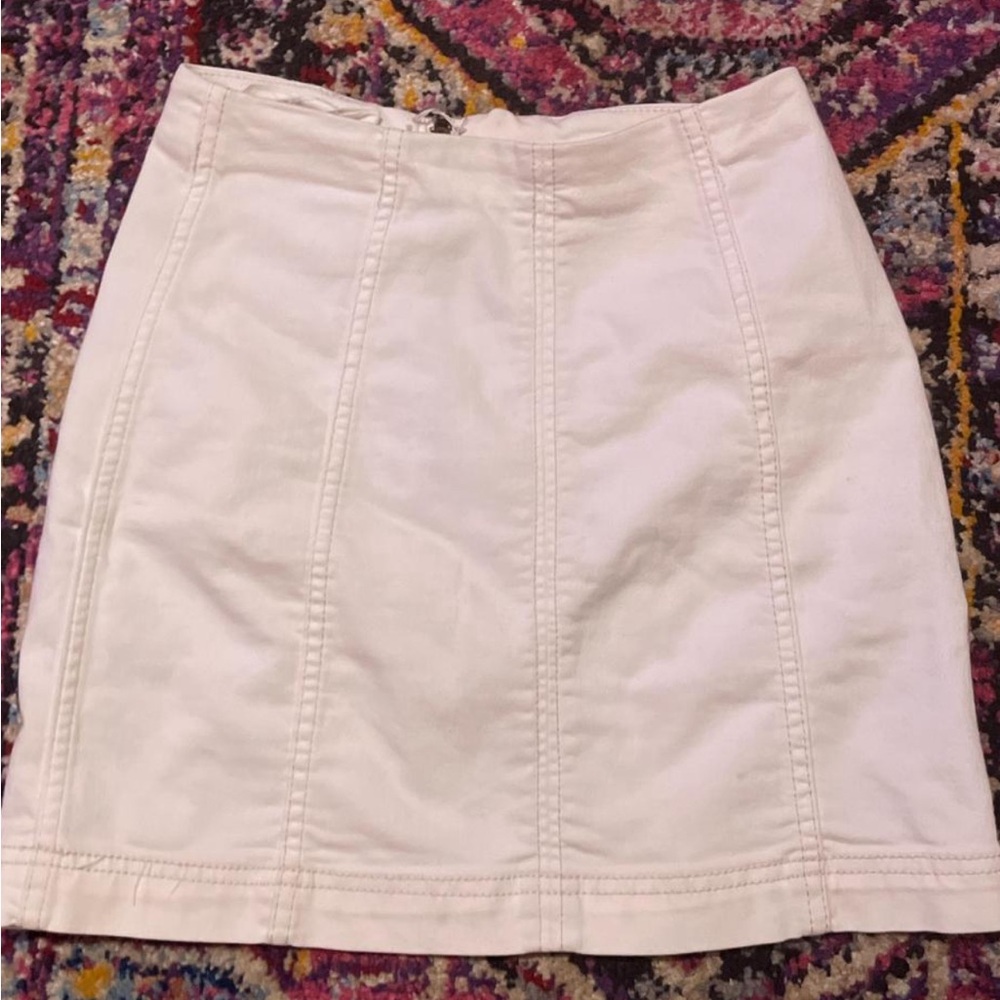 White skirt with hidden zipper closure , hangs above the knees.